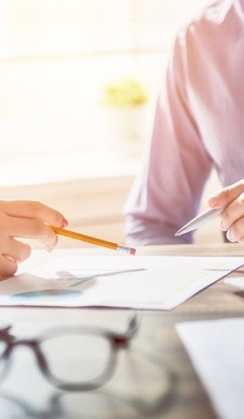 People discussing printed reports on the desk